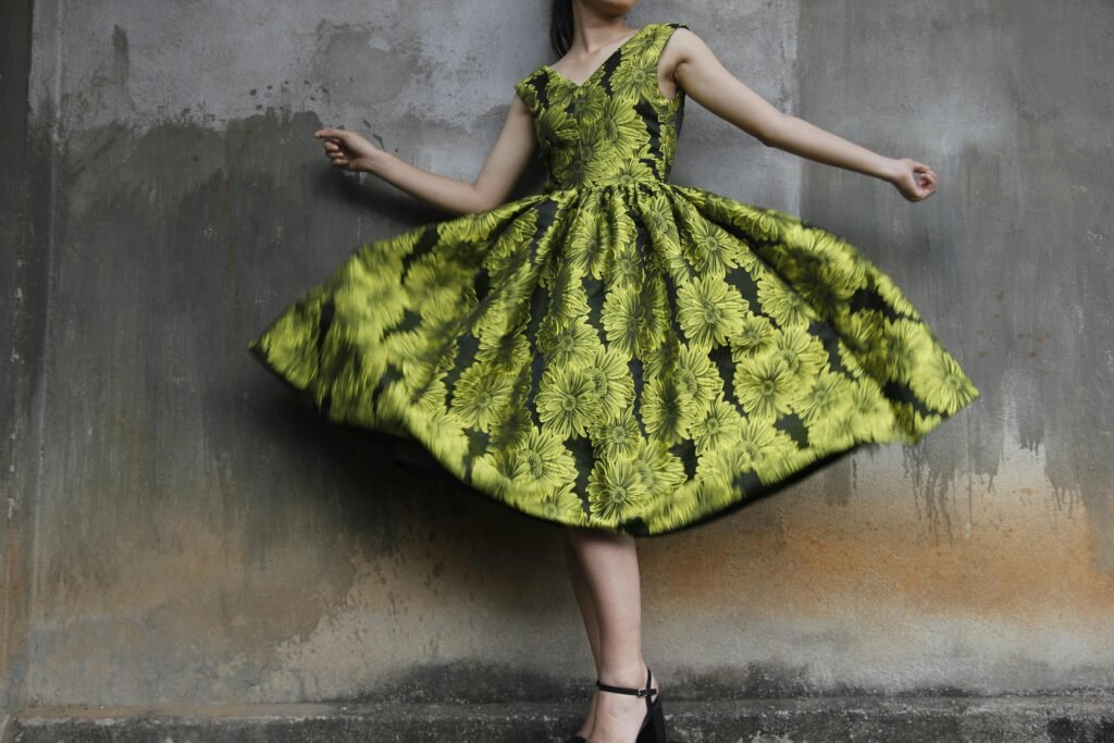 Woman twirling in a vibrant floral dress capturing movement and style.